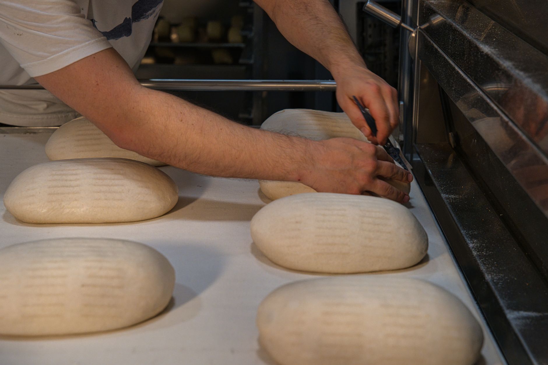 Bäcker formt Brotlaibe